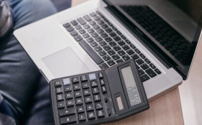 A Laptop and Calculator on a Wooden Table